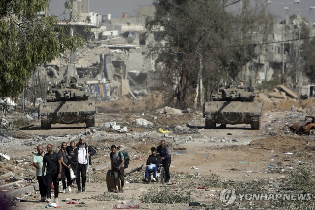 이스라엘 탱크를 뒤로 한 채 가자지구 북부를 떠나는 팔레스타인 주민들